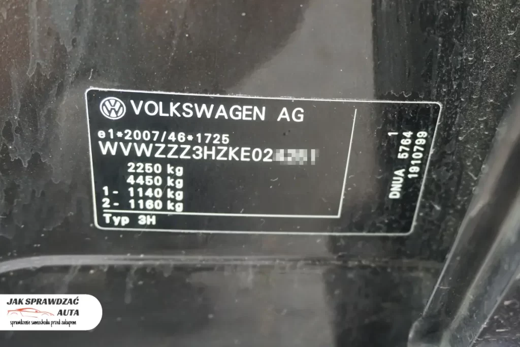 Tabliczka znamionowa z numerem VIN na słupku B w samochodzie marki Volkswagen.