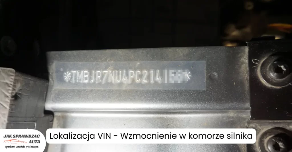 Zbliżenie na numer VIN samochodu marki Škoda wybity na stałym elemencie konstrukcyjnym (wzmocnieniu) w komorze silnika.